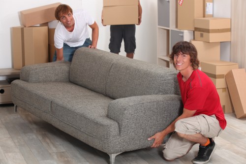 Professional movers loading boxes and protected furniture