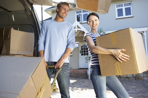 Removal team handling furniture in a Holland Park residential property